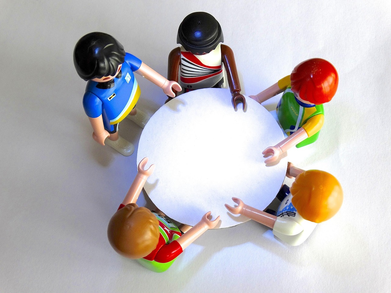 immagine con 5 personaggetti intorno a un tavolo che discutono