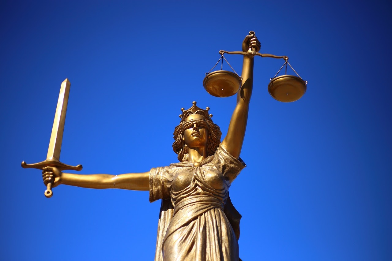 immagine di una statua femminile che tiene la bilancia in una mano e la spada della giustizia nell'altra
